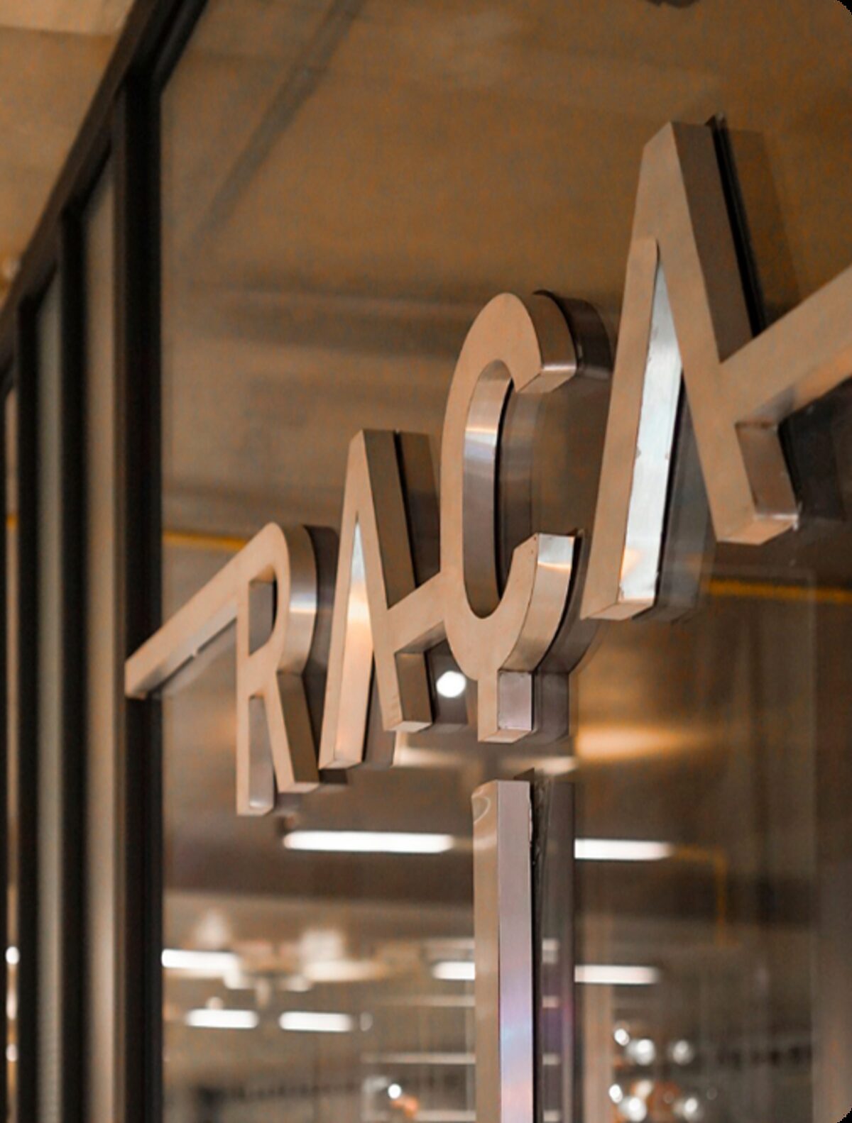 Logotipo Raça em metal escovado na porta do restaurante